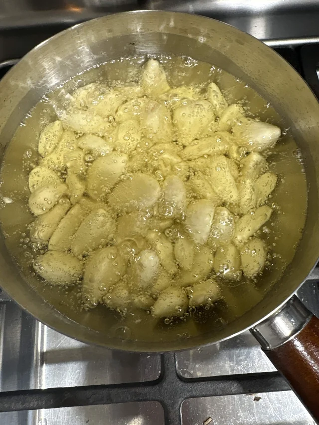 Small pastries bubbling in a pan of hot oil.